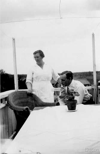 1936 Hildur och Knut på balkong.jpg - Fotograf Hildur och Frisör Knut har lunch rast året är 1930 samma år etablerades en färghandel kemikalie och sjukvårdsaffär i den nyinköpta fastigheten som förvärvades för 12.000:-. Nu hade drömmen om att ha verksamheterna under samma tak förverkligats.